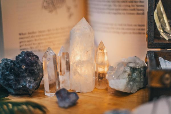 Close-up of various healing crystals on a wooden table with warm lighting