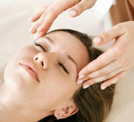 Woman receiving a soothing facial massage in a relaxing spa environment.