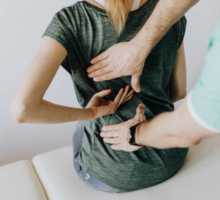 A chiropractor examining a patient's back to alleviate pain and discomfort.